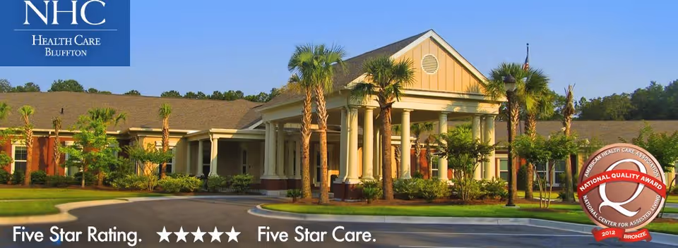 Exterior view of NHC HealthCare Bluffton with palm trees and the entrance.