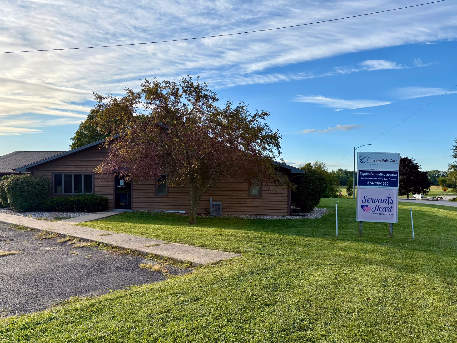 Single-story brown building with a lawn sign reading Servants Heart Home Health
