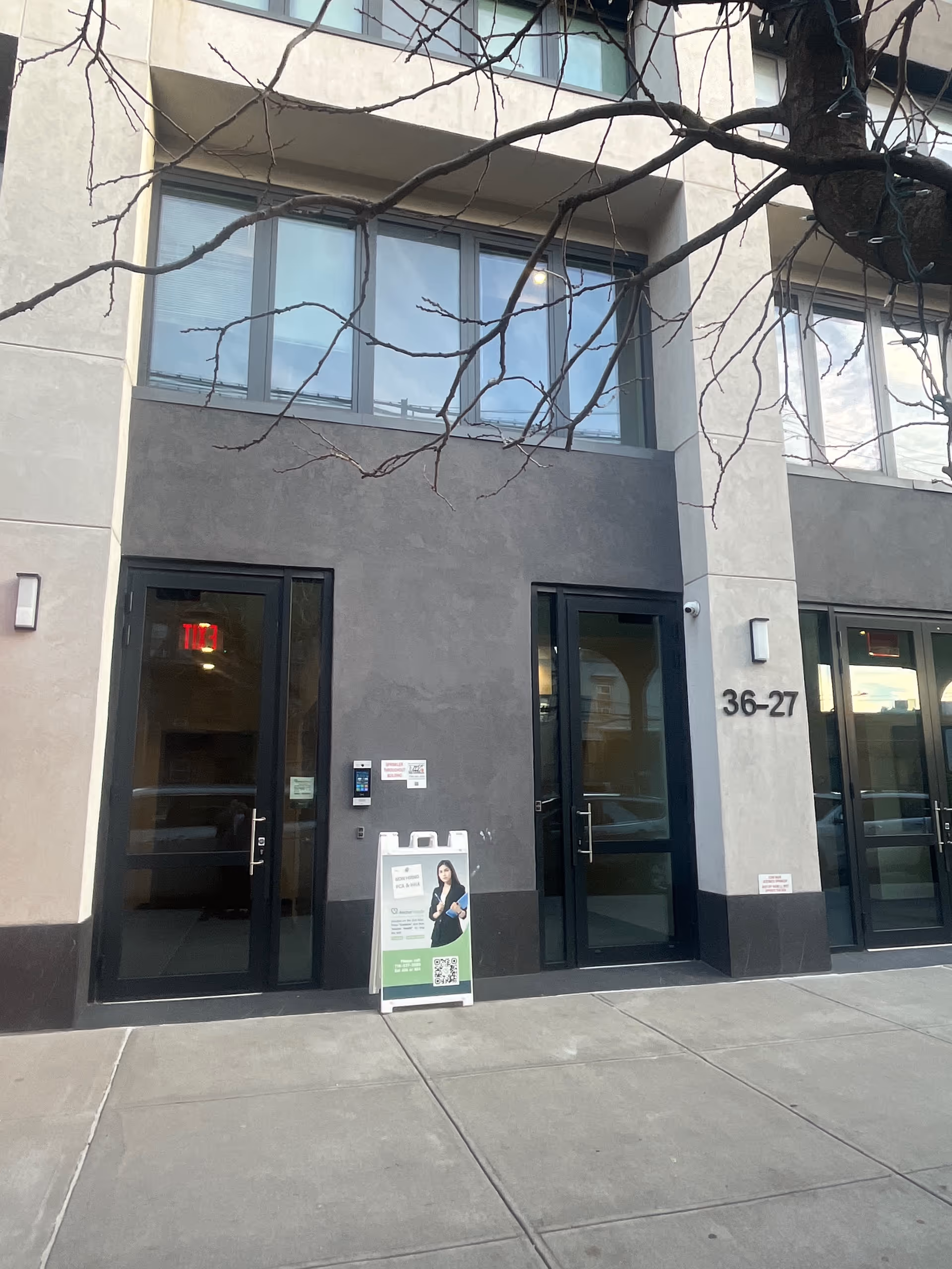 Modern facility entrance with glass doors and large windows beside the 36-27 address.