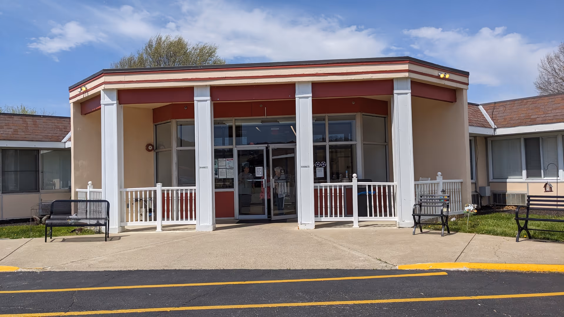 Front view of Mountain View Care Center entrance with columns and benches outside.