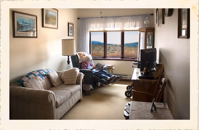 Cozy living room at Warm Valley Lodge with a resident watching TV.