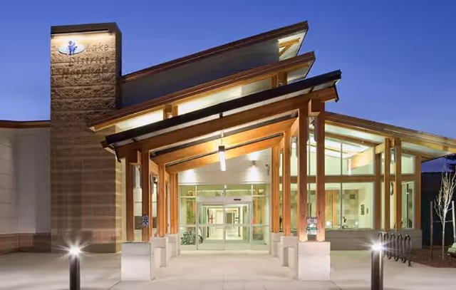 Front entrance of Lake Health District facility with glass doors and wooden canopy.
