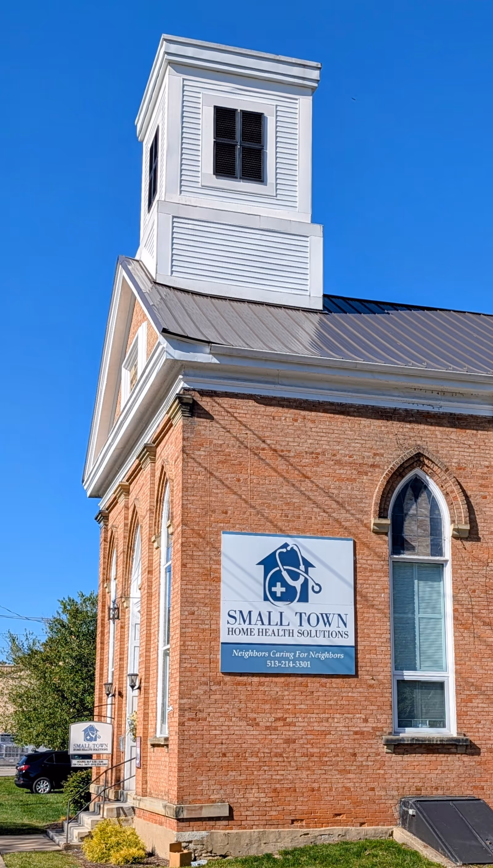 Brick building with a white cupola and Small Town Home Health Solutions sign on the front.