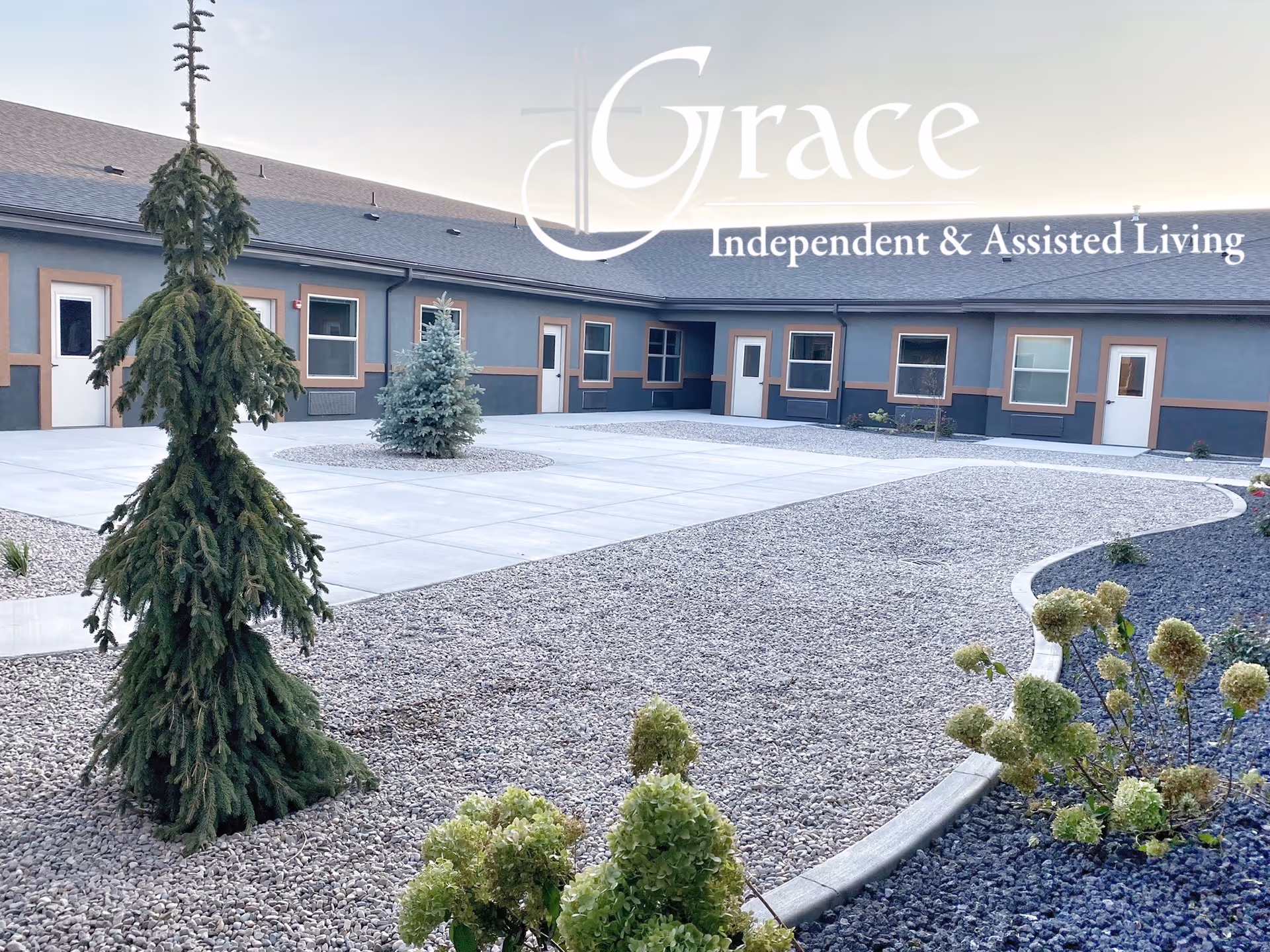 Exterior view of Grace Independent & Assisted Living with a gravel courtyard and entry doors.