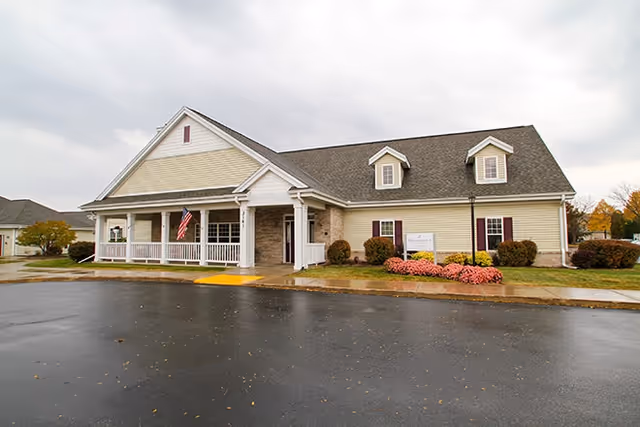 A single-story senior living facility with a covered front porch and landscaped yard.