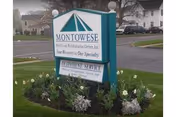 Exterior sign for Montowese Center for Health and Rehabilitation amid flowering landscape.