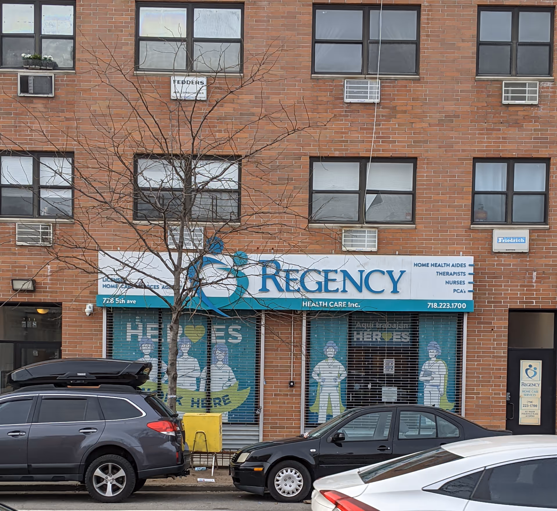 Brick building facade with Regency Health Care storefront sign and parked cars in front.