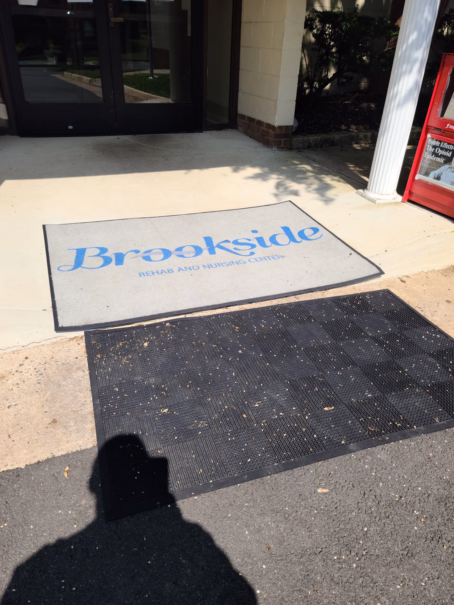Entrance mat reads Brookside Rehab and Nursing Centers outside a glass door.