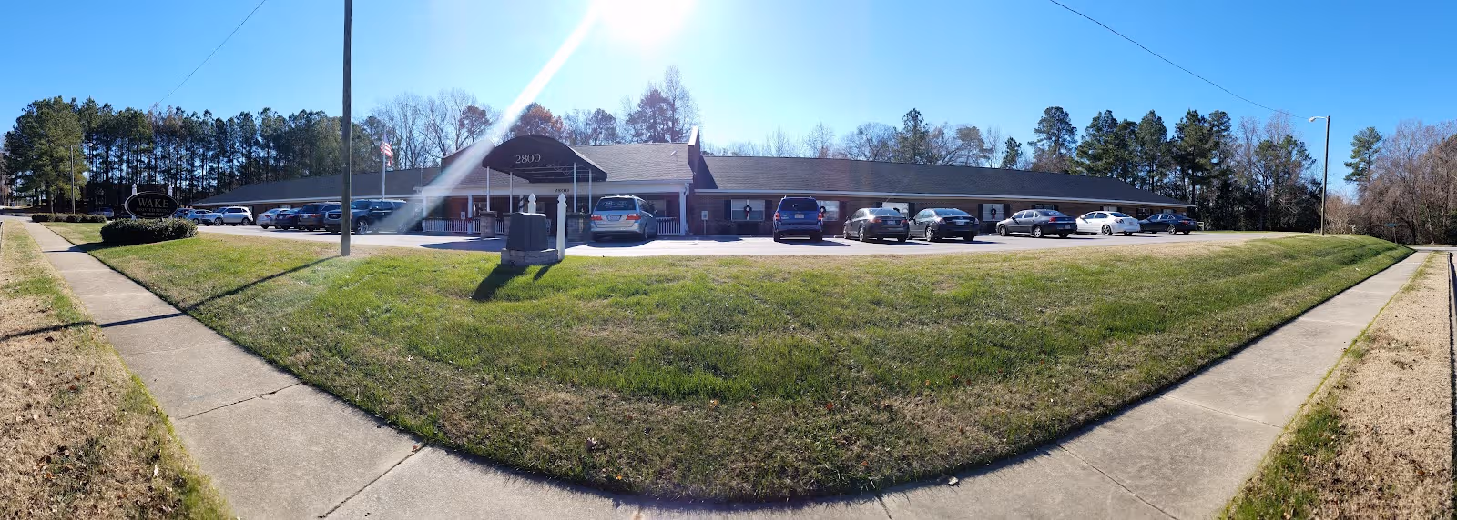 Exterior view of Wake Assisted Living Memory Care with parked cars by the entrance.