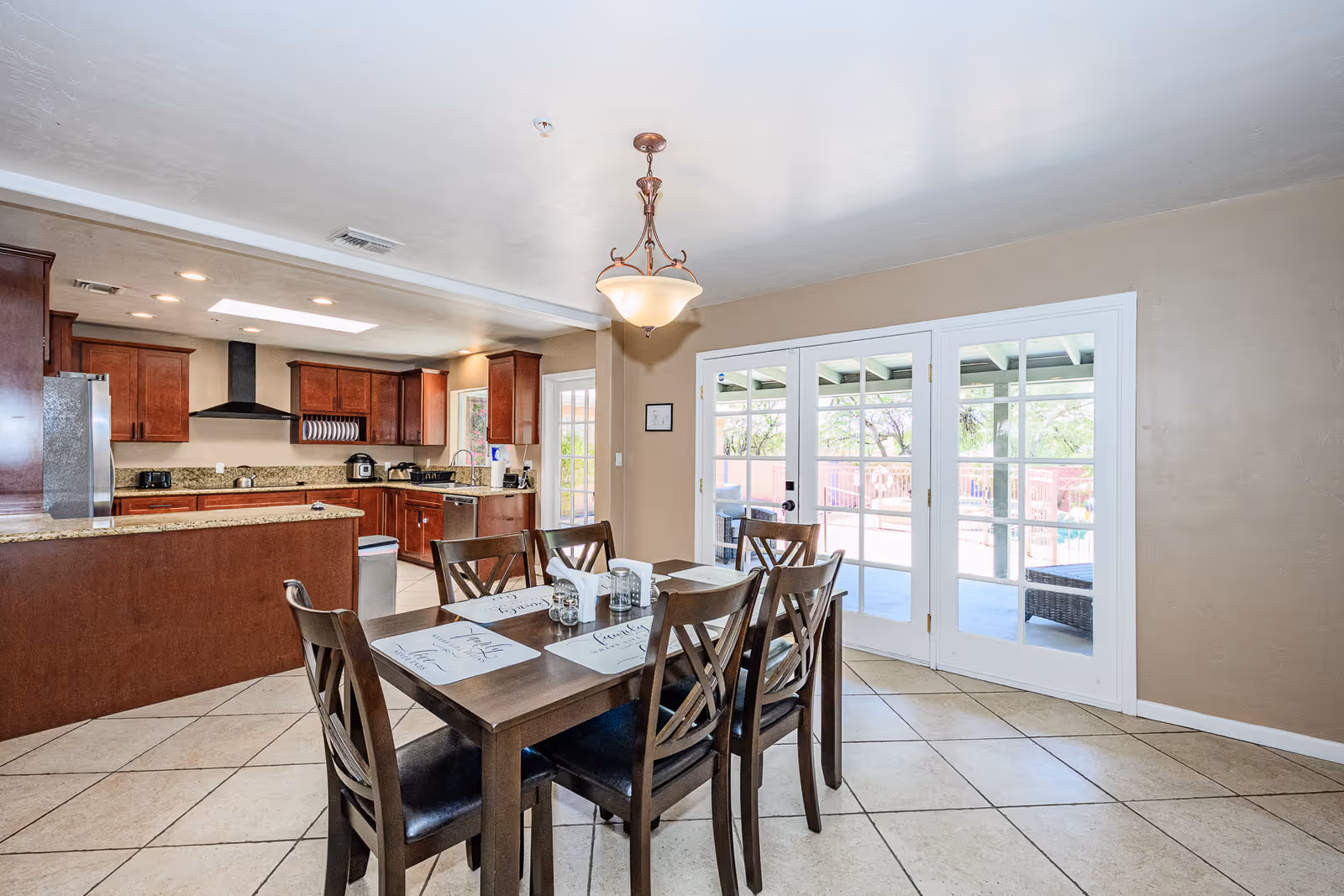 Dining room with a dark wood table, chairs, and glass doors to the patio.