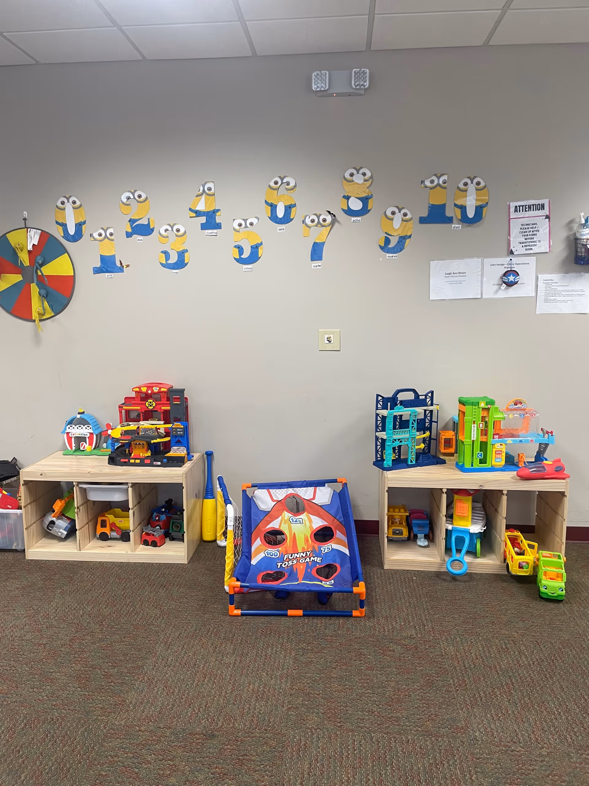 Interior children's playroom with cubbies, toys, a mini basketball toss game, and wall decals.