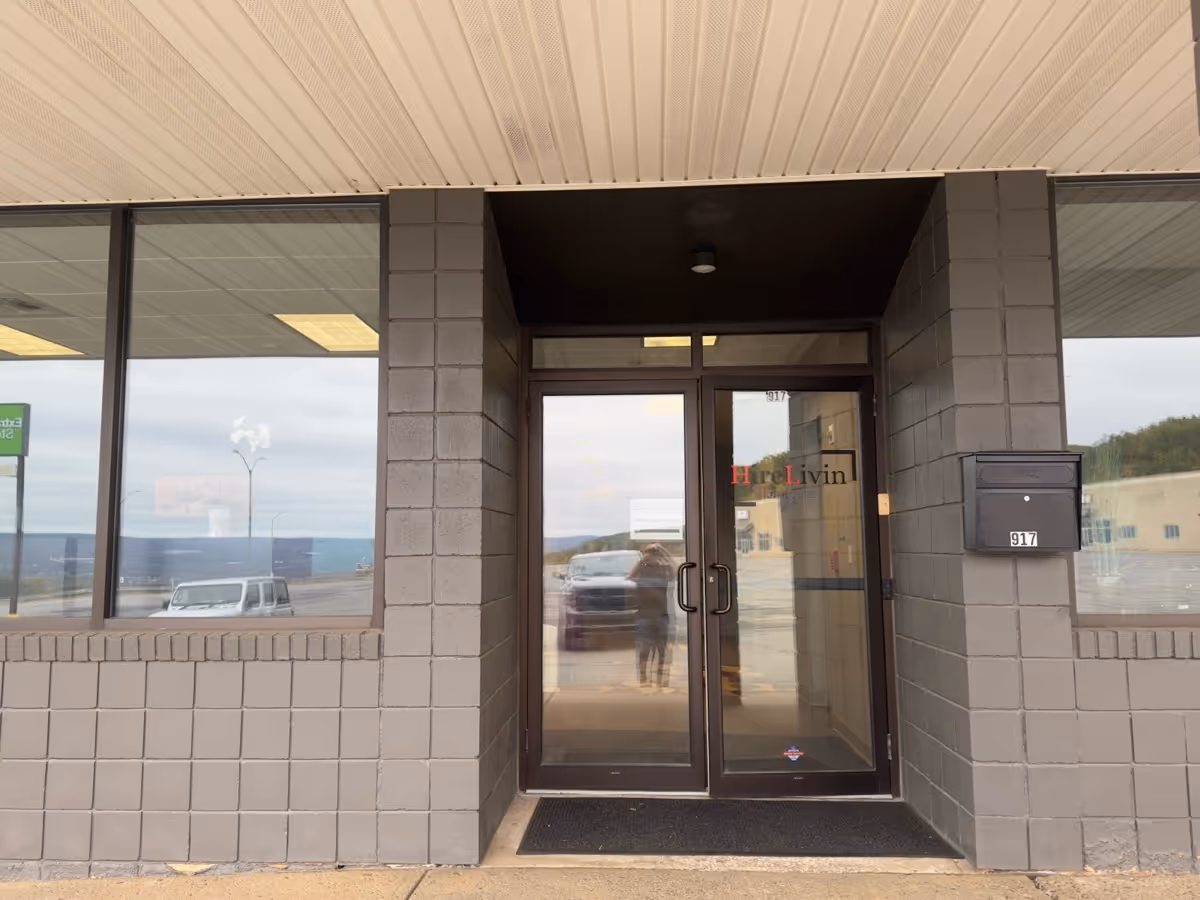 Glass double doors entrance to HireLivin Homecare LLC, brick exterior, mailbox beside door.