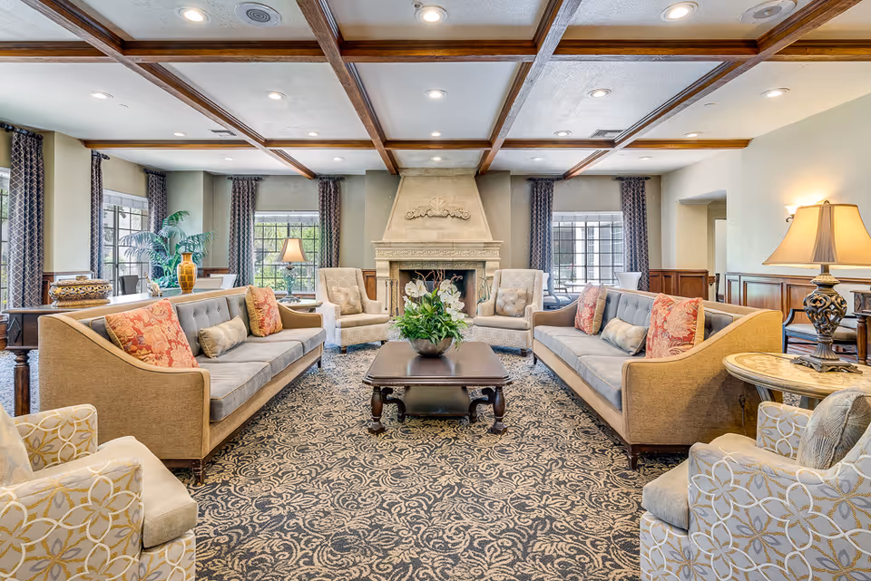 Spacious living room with sofas, chairs, fireplace, and patterned carpet.