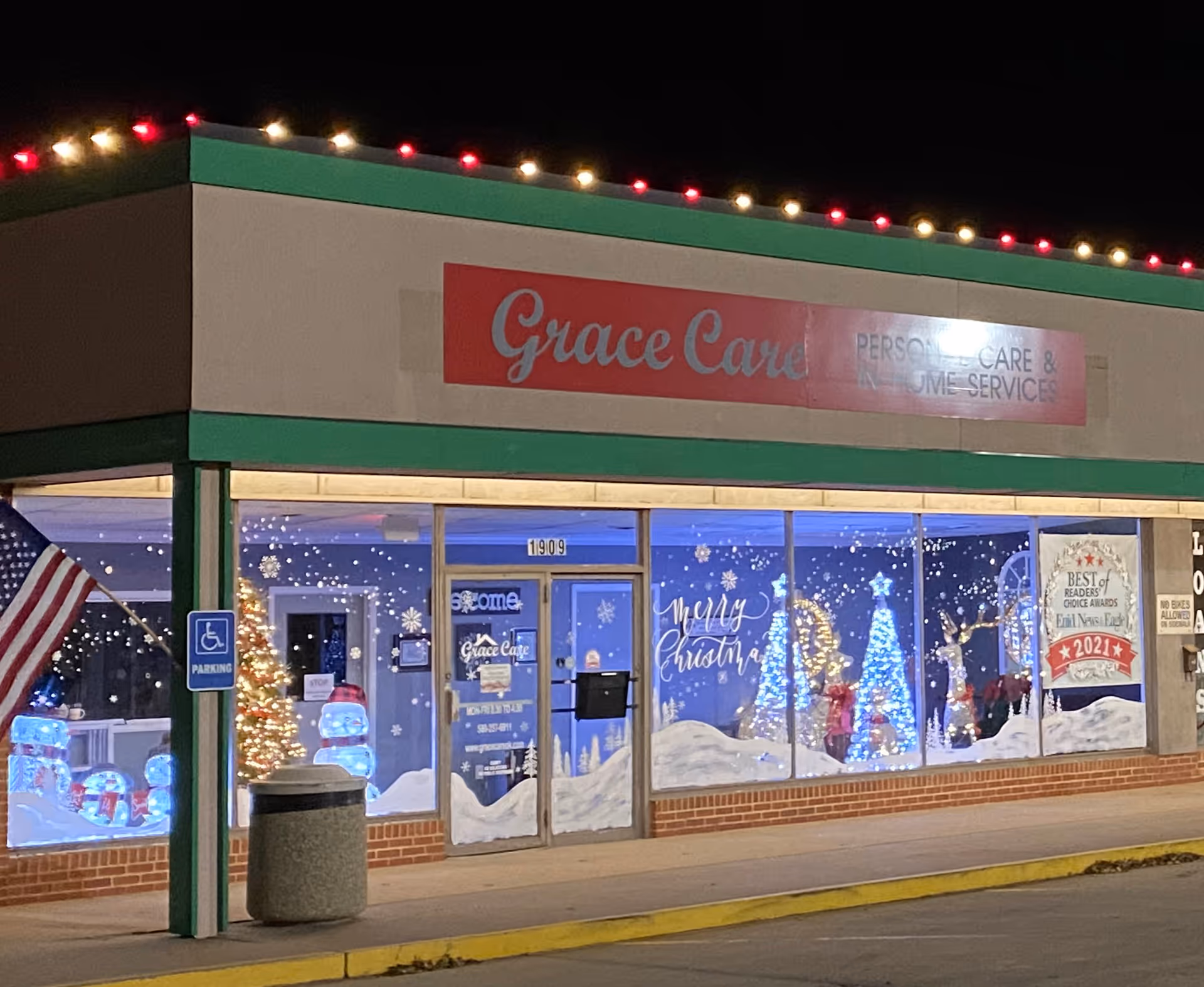 Nighttime storefront of Grace Care with holiday decorations and snow-themed window displays.