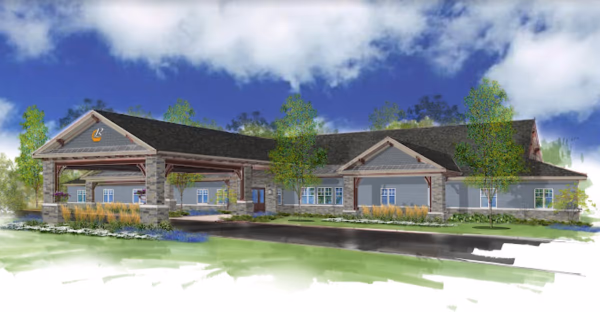 Illustration of the front exterior of a single-story senior living facility building with a covered entrance supported by stone pillars, surrounded by trees and landscaping under a partly cloudy blue sky.