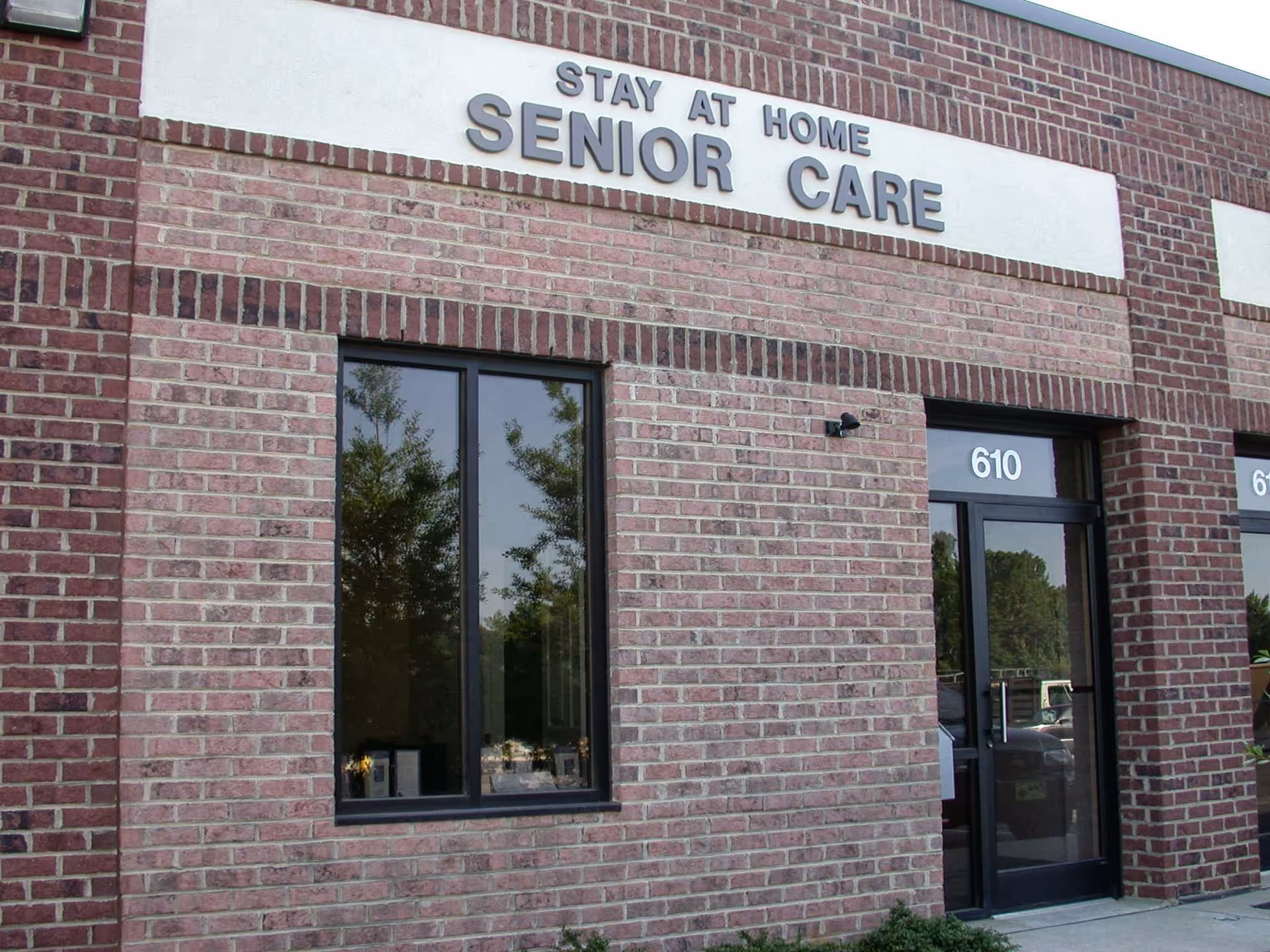 Brick exterior of a senior care facility with Stay at Home Senior Care sign.