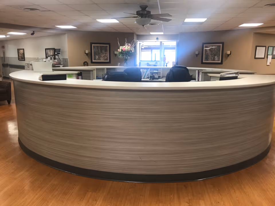 Curved reception desk in a spacious, well-lit senior living lobby.