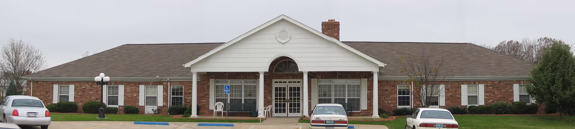 Front exterior of Mt. Vernon Place Care Center with parked cars.