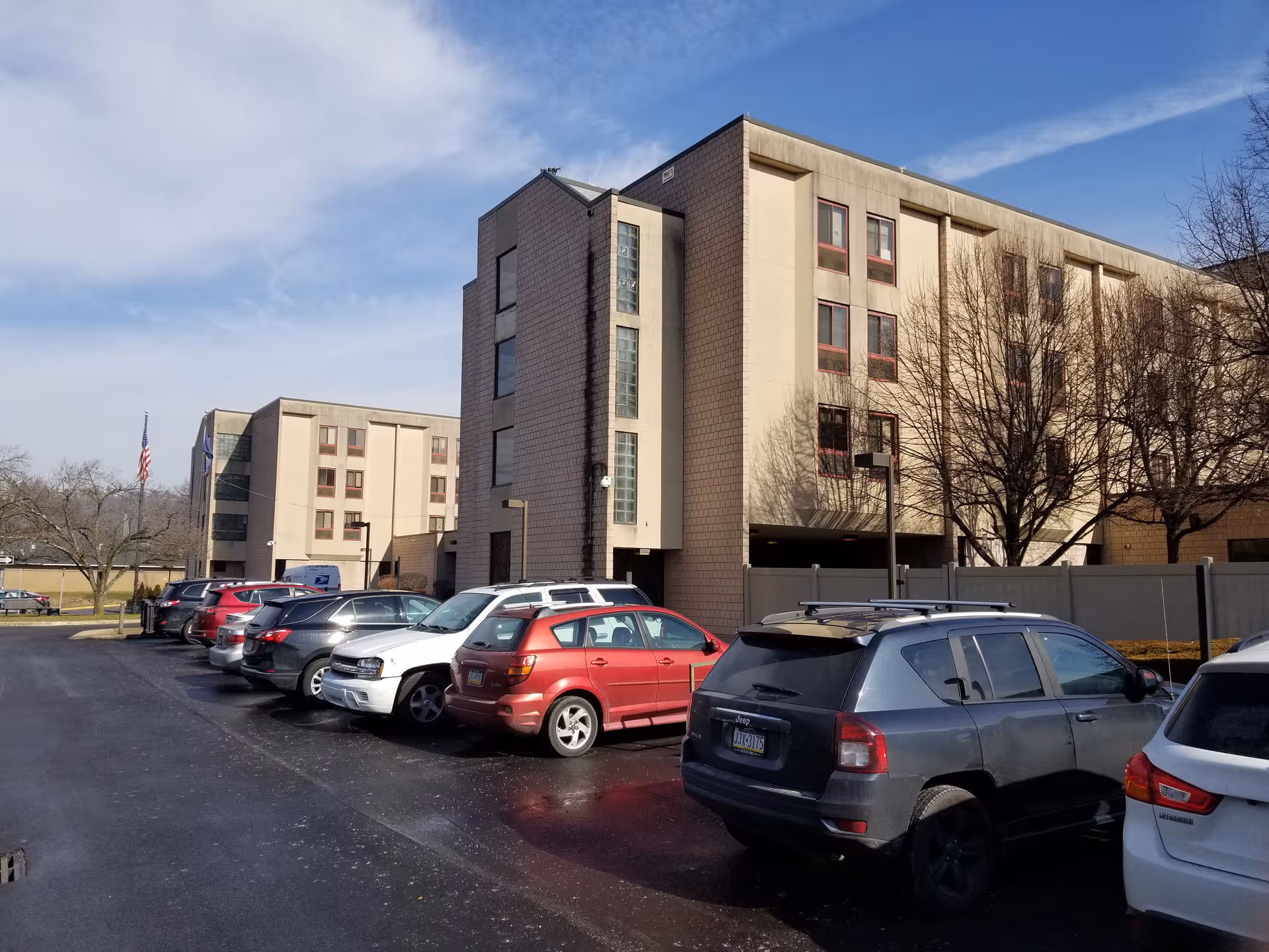 Exterior view of Kane Community Living Center; several cars parked in front.