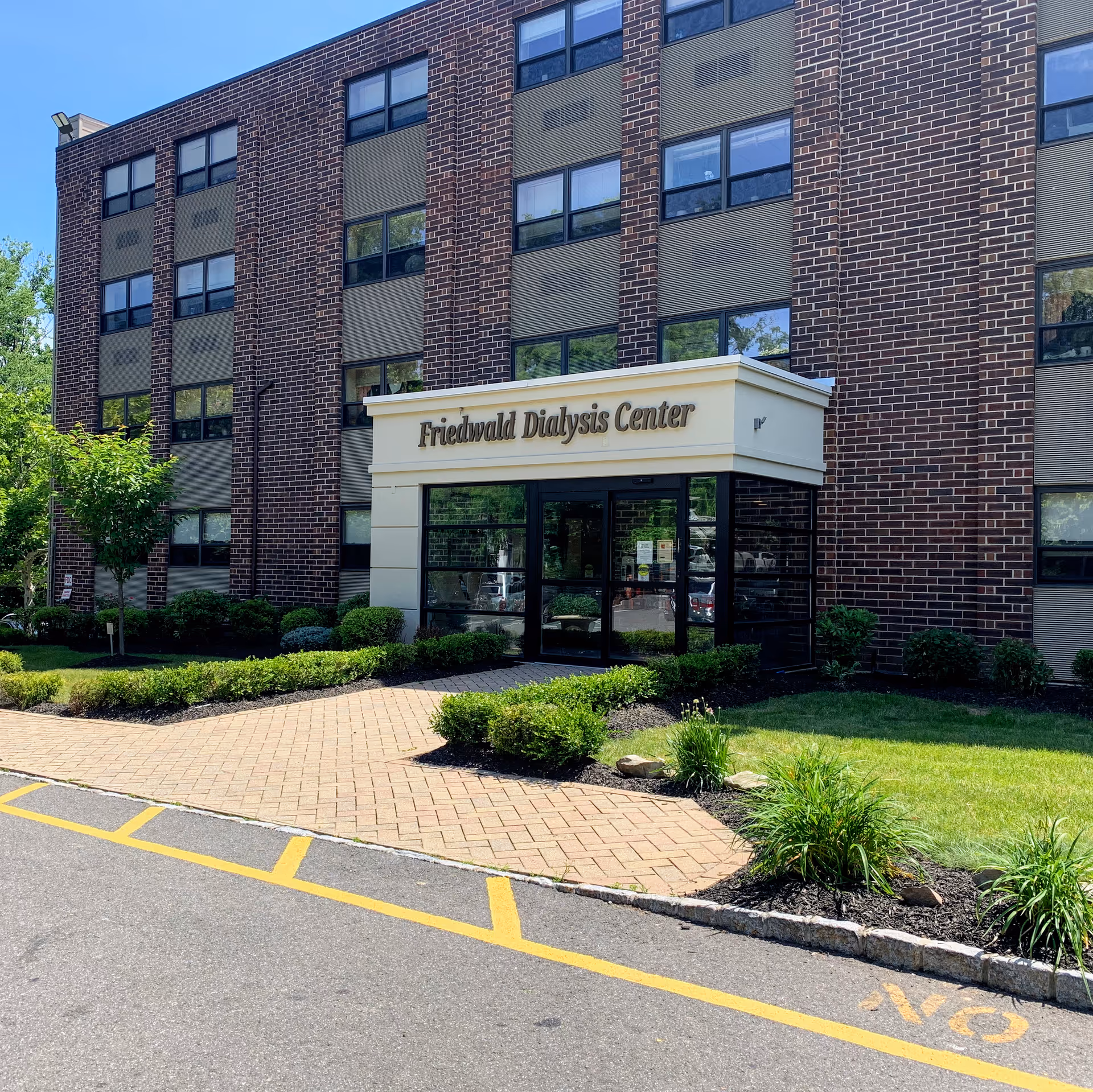 Brick exterior building with a glass entrance labeled Friedwald Dialysis Center.