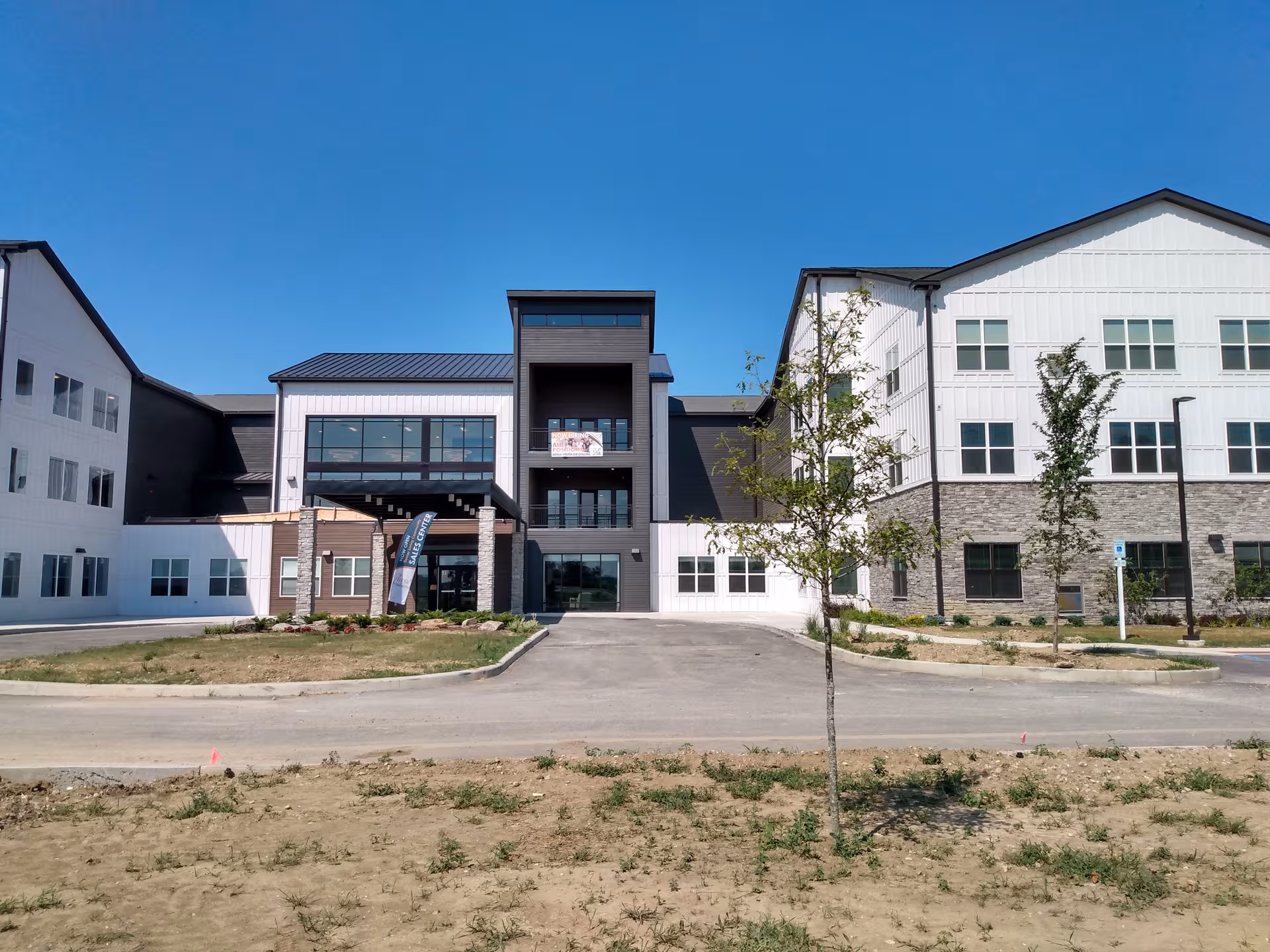 Astral at Franklin senior living facility exterior with driveway and trees.