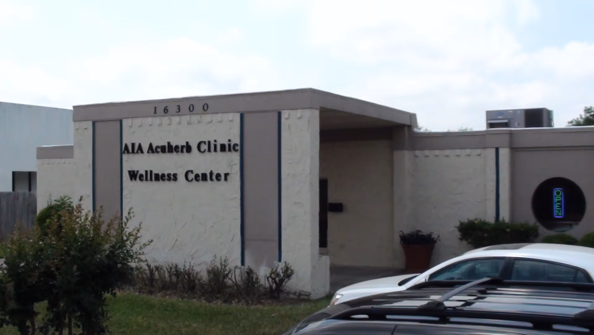 Front exterior of a clinic building with AIA Acherb Clinic Wellness Center sign.