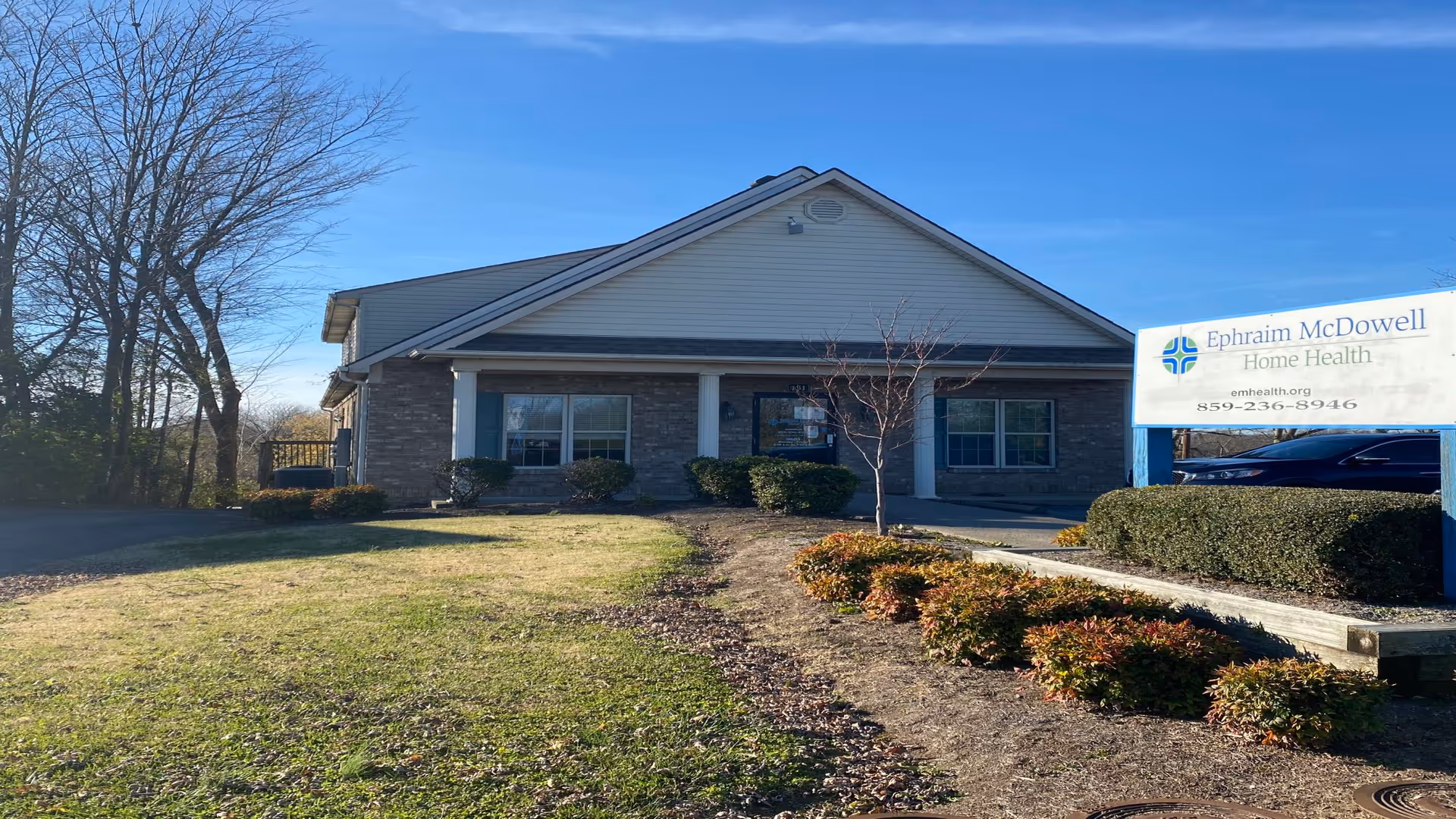 Single-story facility with a lawn, shrubs, and a sign reading Ephraim McDowell Home Health.