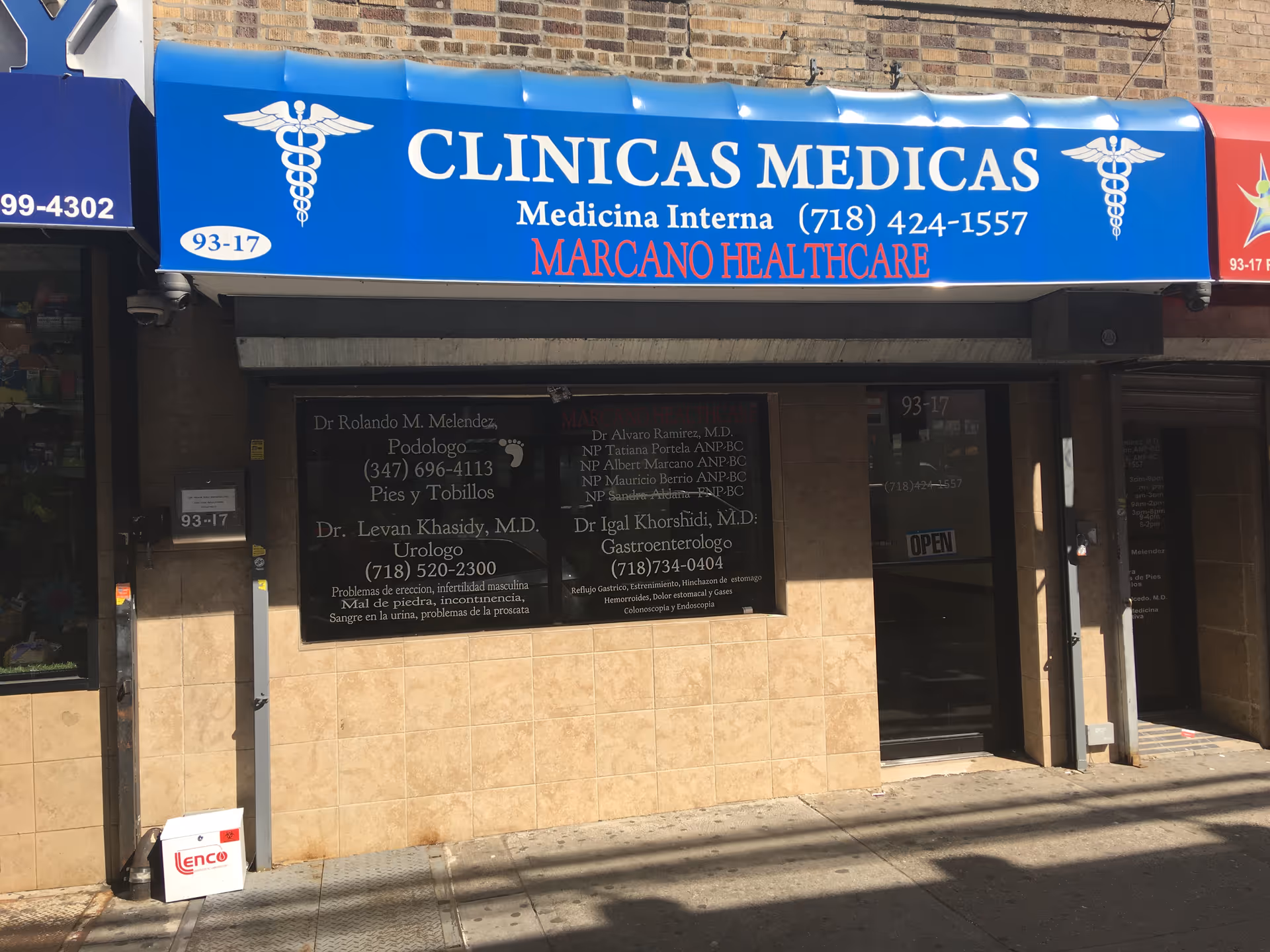 Blue storefront sign reading Clinicas Medicas and Marcano Healthcare over beige tiled exterior.
