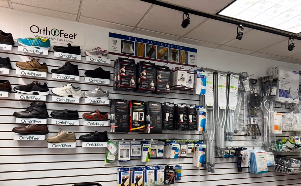 Wall-mounted display of orthopedic shoes and medical supplies in a retail interior.