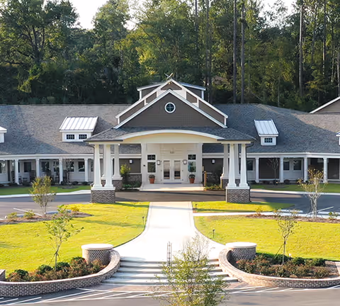 Front exterior view of Thrive at Augusta building with a curved walkway and lawn.