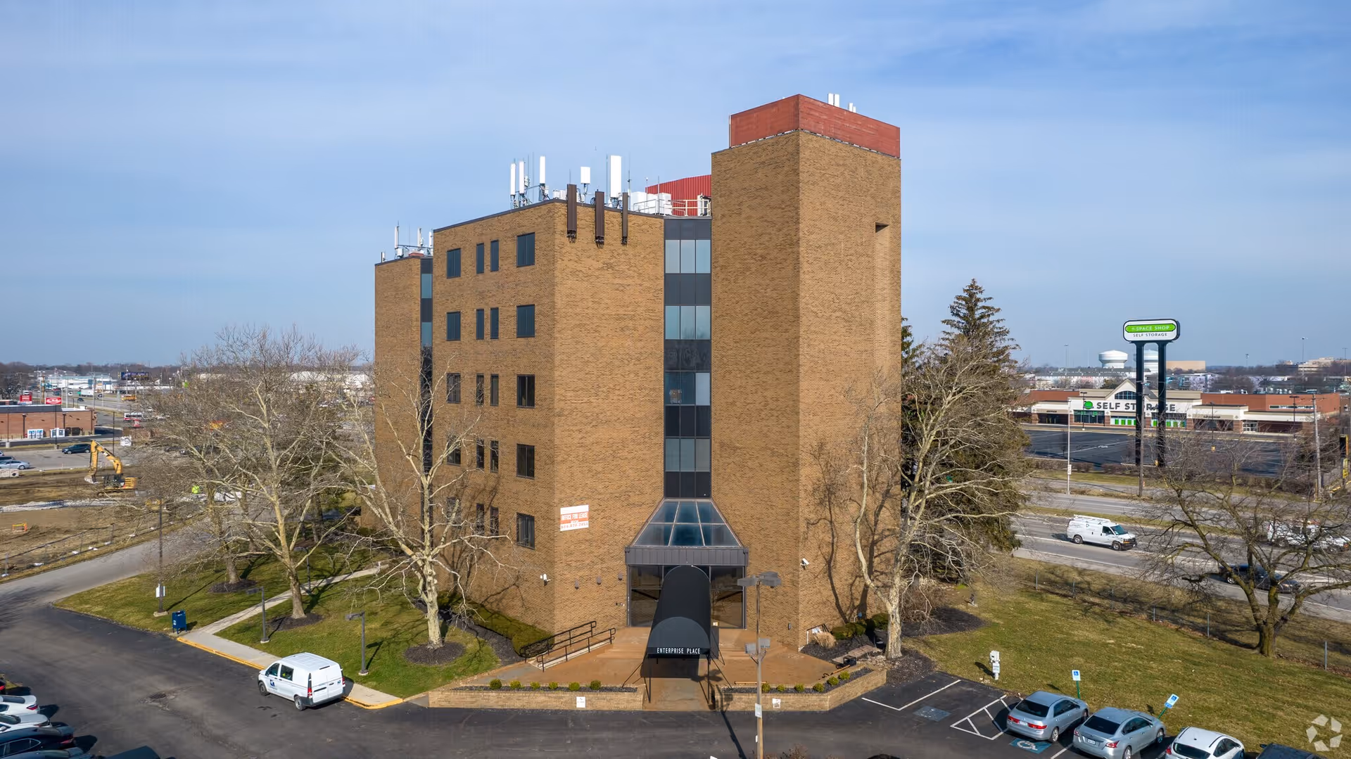 A multi-story brick senior living facility with a glass front entrance.