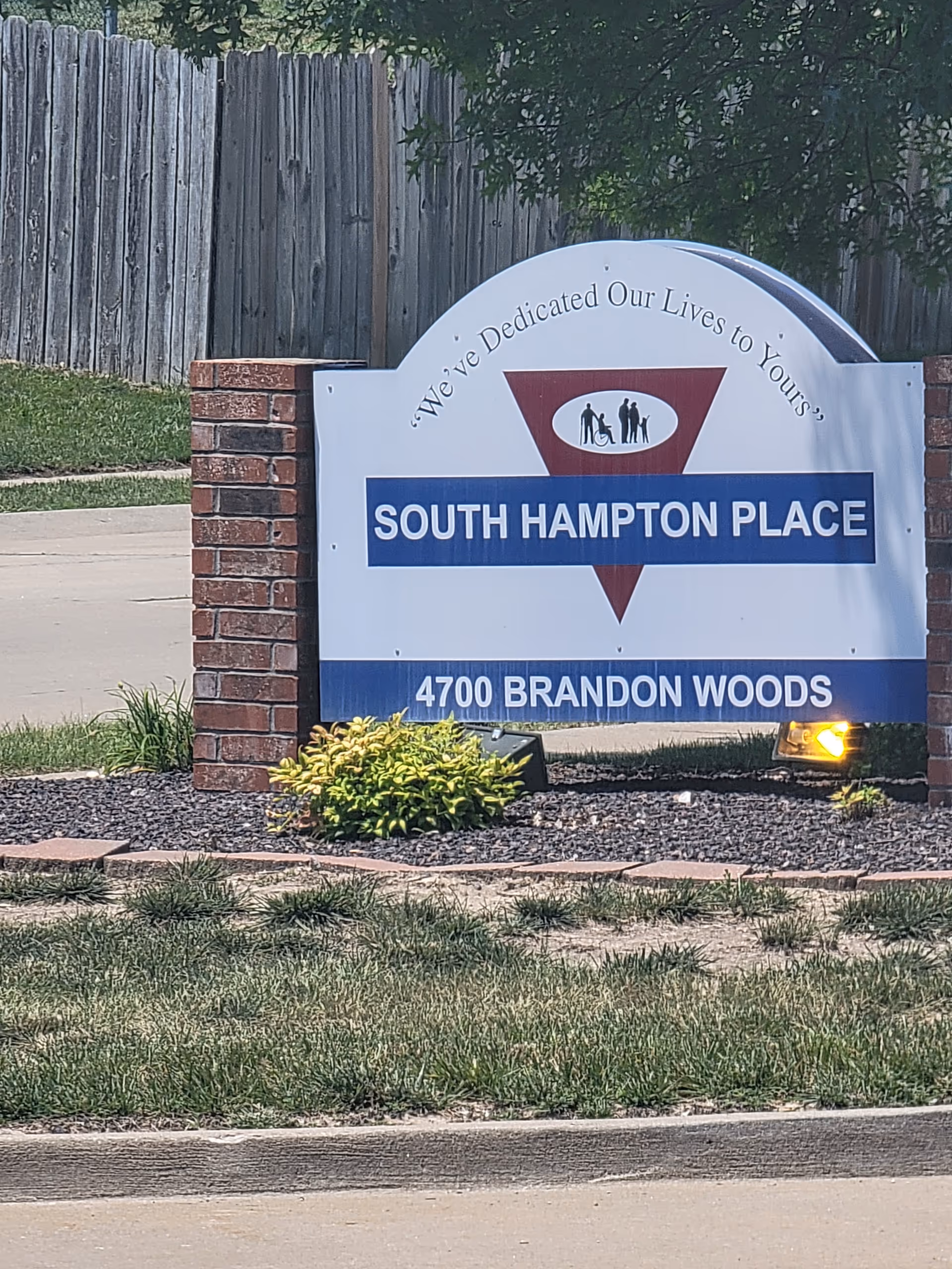 Front entrance sign for South Hampton Place with brick posts and landscaping.
