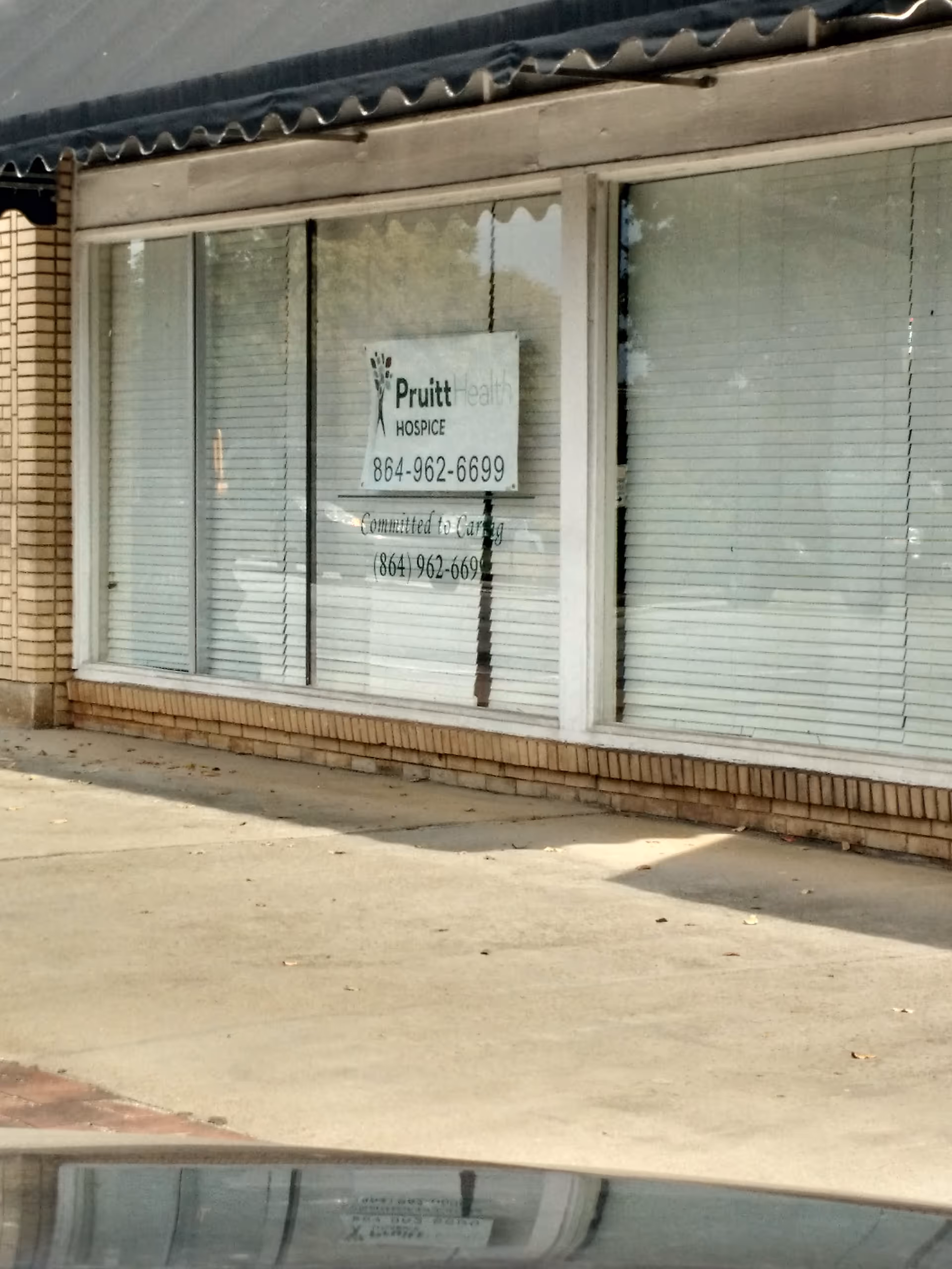 Exterior view of hospice storefront with blinds in windows and a PruittHealth sign