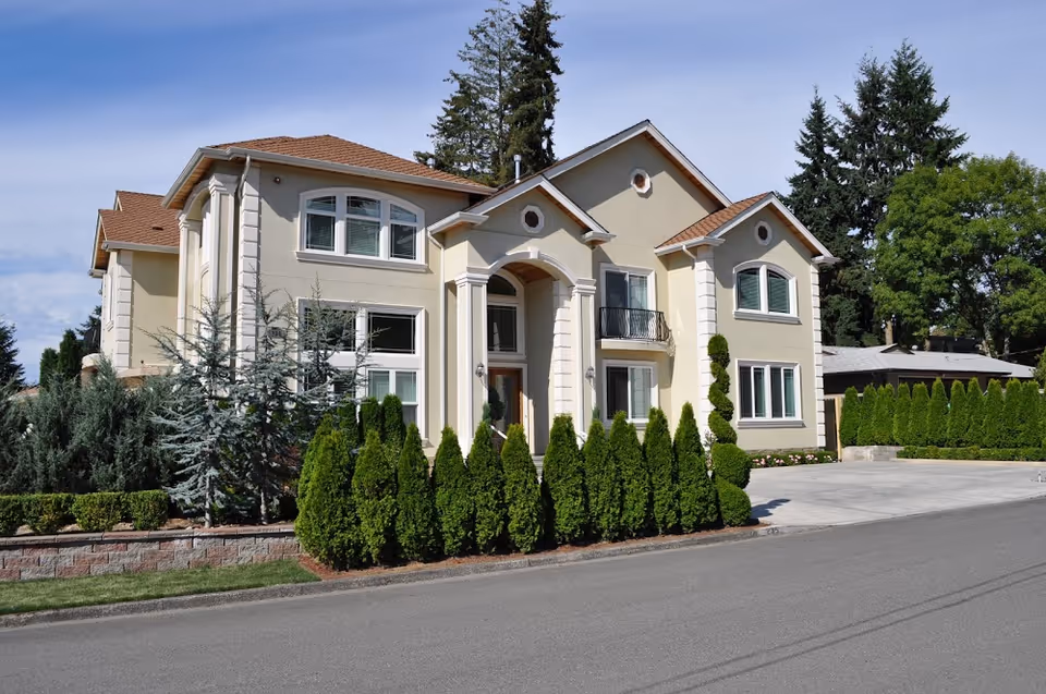 Exterior view of a Bellevue Senior Living facility with a grand entrance and trimmed hedges.
