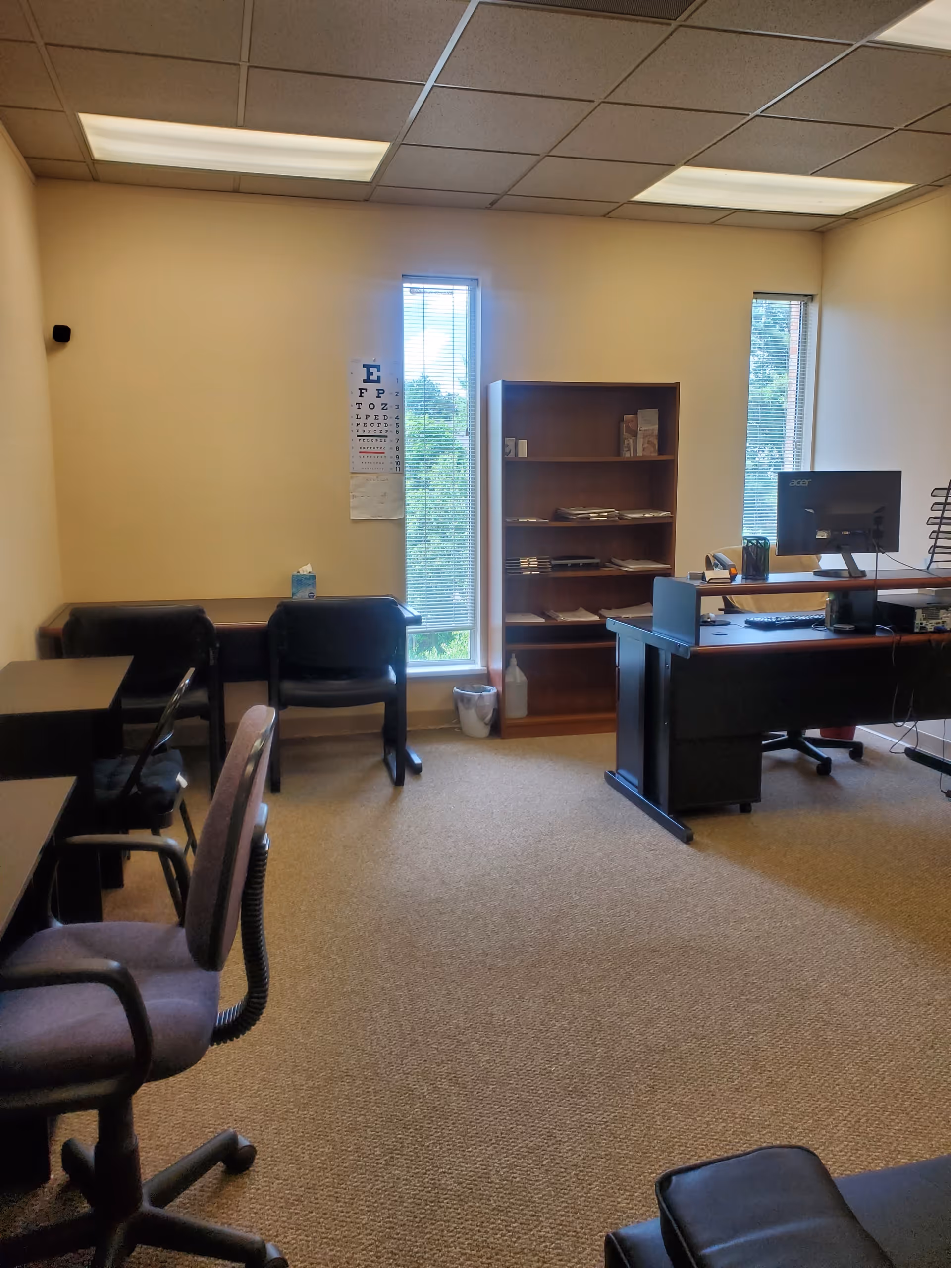 Interior office area featuring desk, computer, bookshelf, and several chairs in a calm facility.