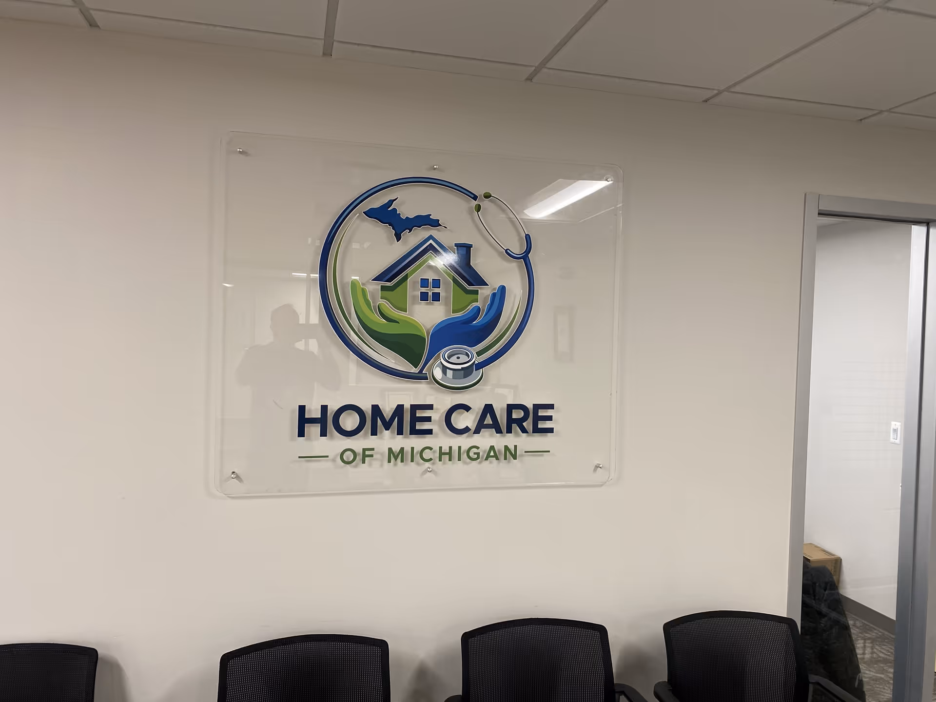 Interior wall sign for Home Care of Michigan with logo and chairs.