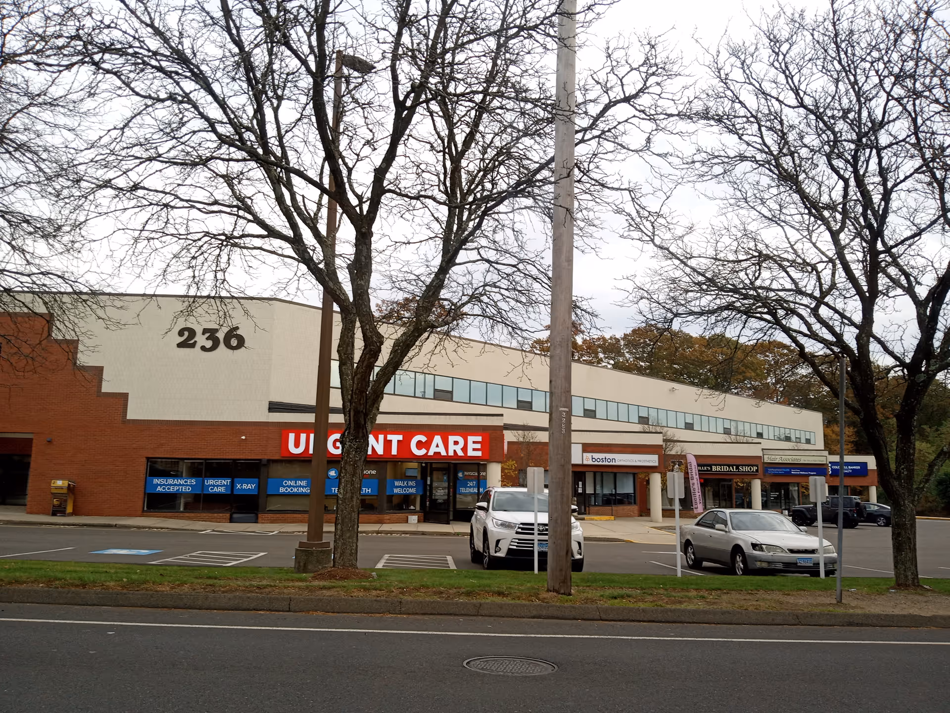 Exterior view of a strip mall featuring Uplifting Elderly Home Care storefront and parked cars.