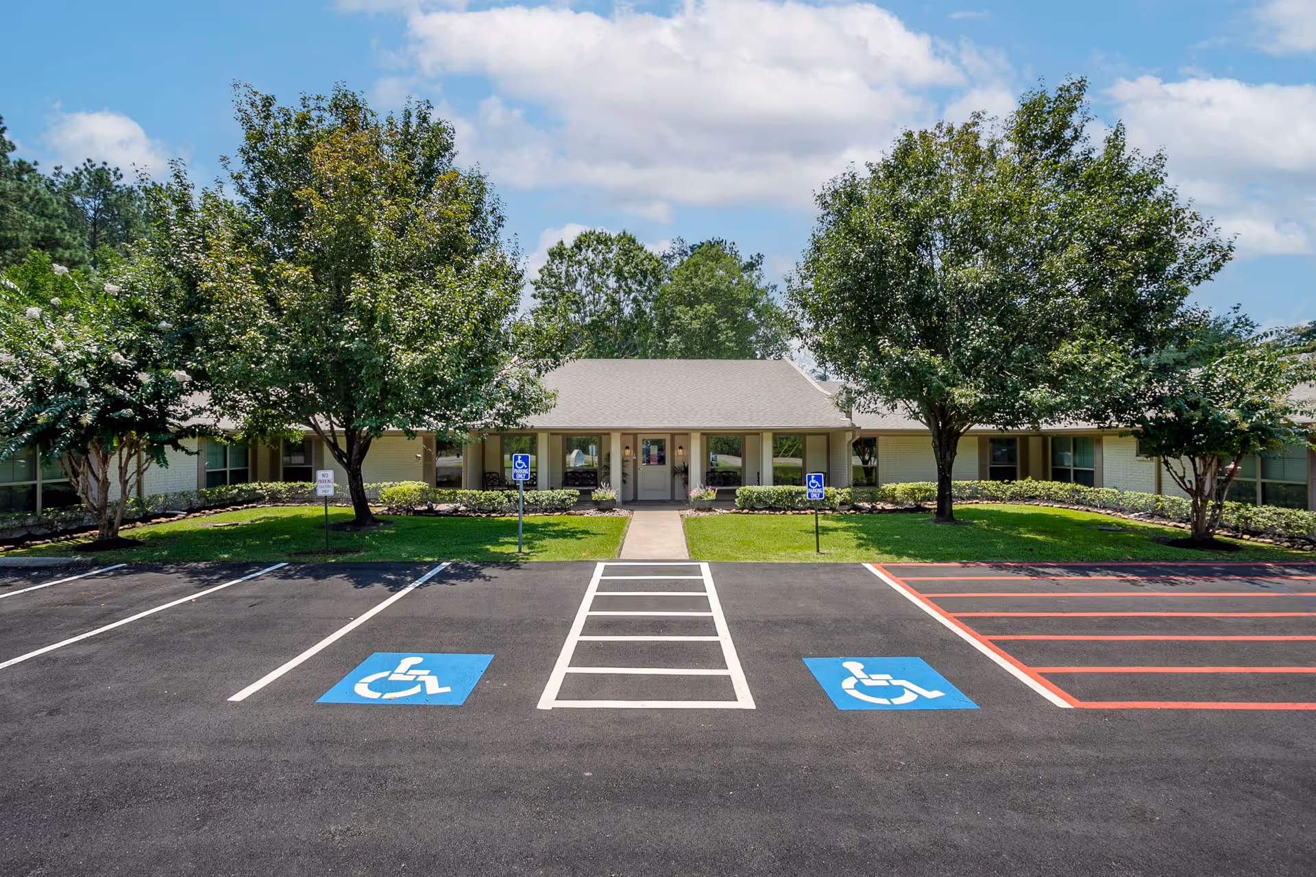 Front exterior of a senior living facility with accessible parking spaces.