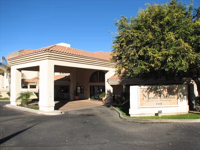 Exterior view of an assisted living facility entrance with a covered drive.