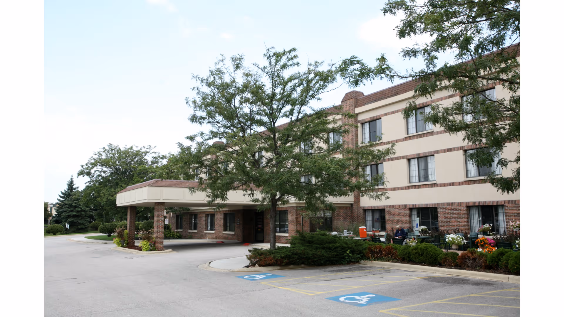 Front view of Bella Terra Schaumburg senior living building with entrance and landscaping.