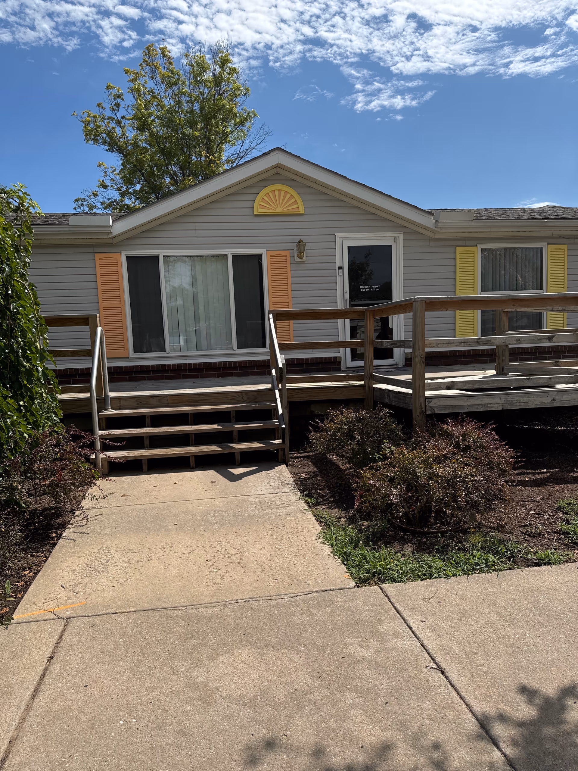 Front exterior of a single-story senior care home with a ramp and steps.