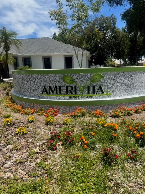 Exterior view of Amerivita Home Care sign with colorful flowers in front