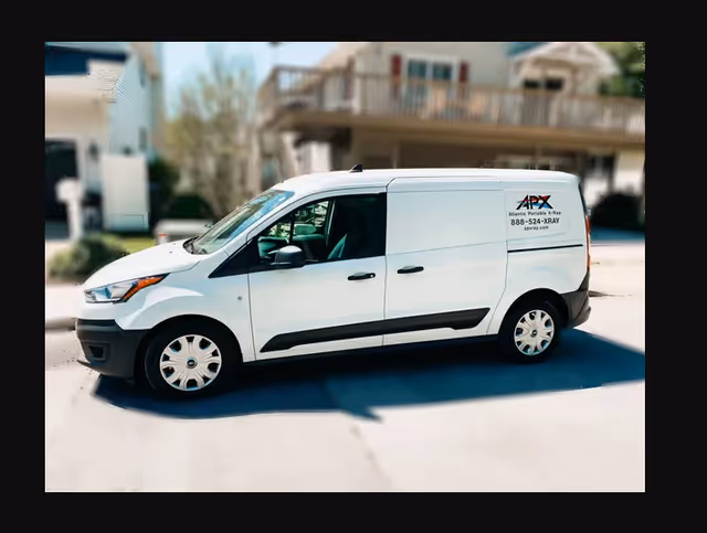 White service van labeled Atlantic Portable X-ray parked outside a senior living facility.