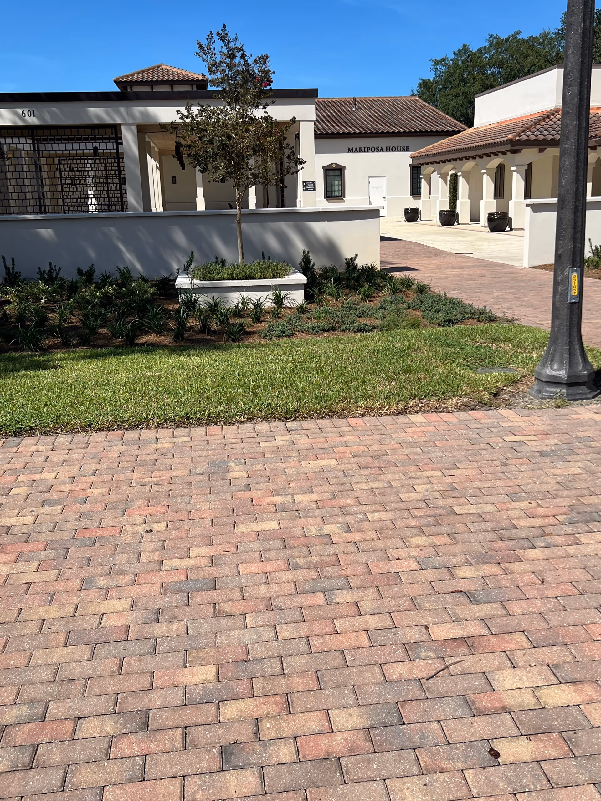Exterior view of Cornerstone Hospice building with brick walkway and landscaped courtyard.