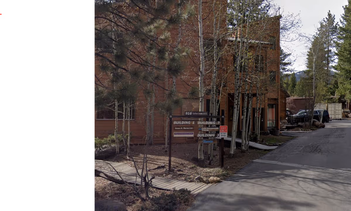 Exterior of a brick senior living facility with signposts and a paved driveway