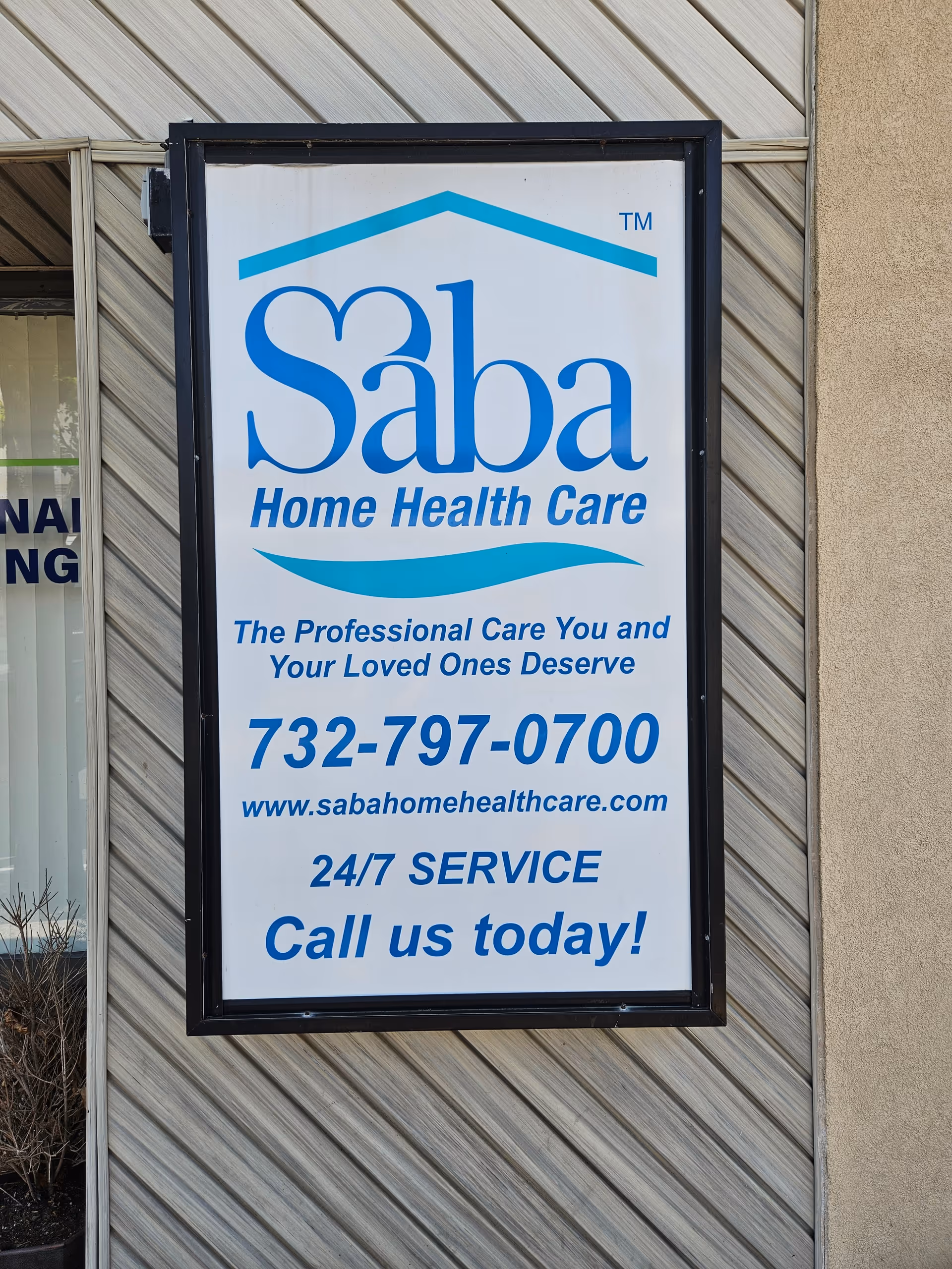 Framed Saba Home Health Care sign on the building exterior showing contact info.