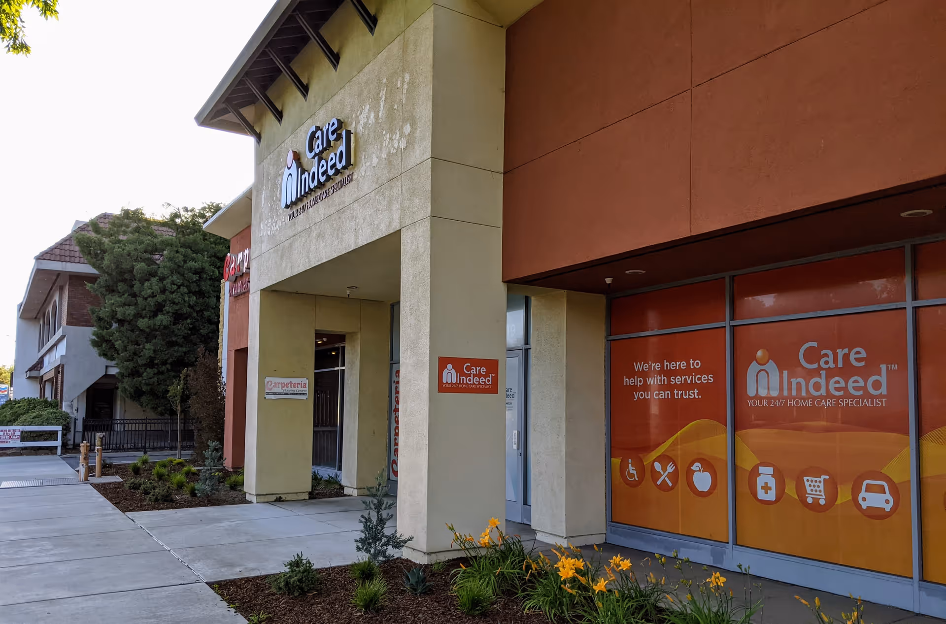 Exterior view of Care Indeed facility with its front entrance and orange storefront signage.