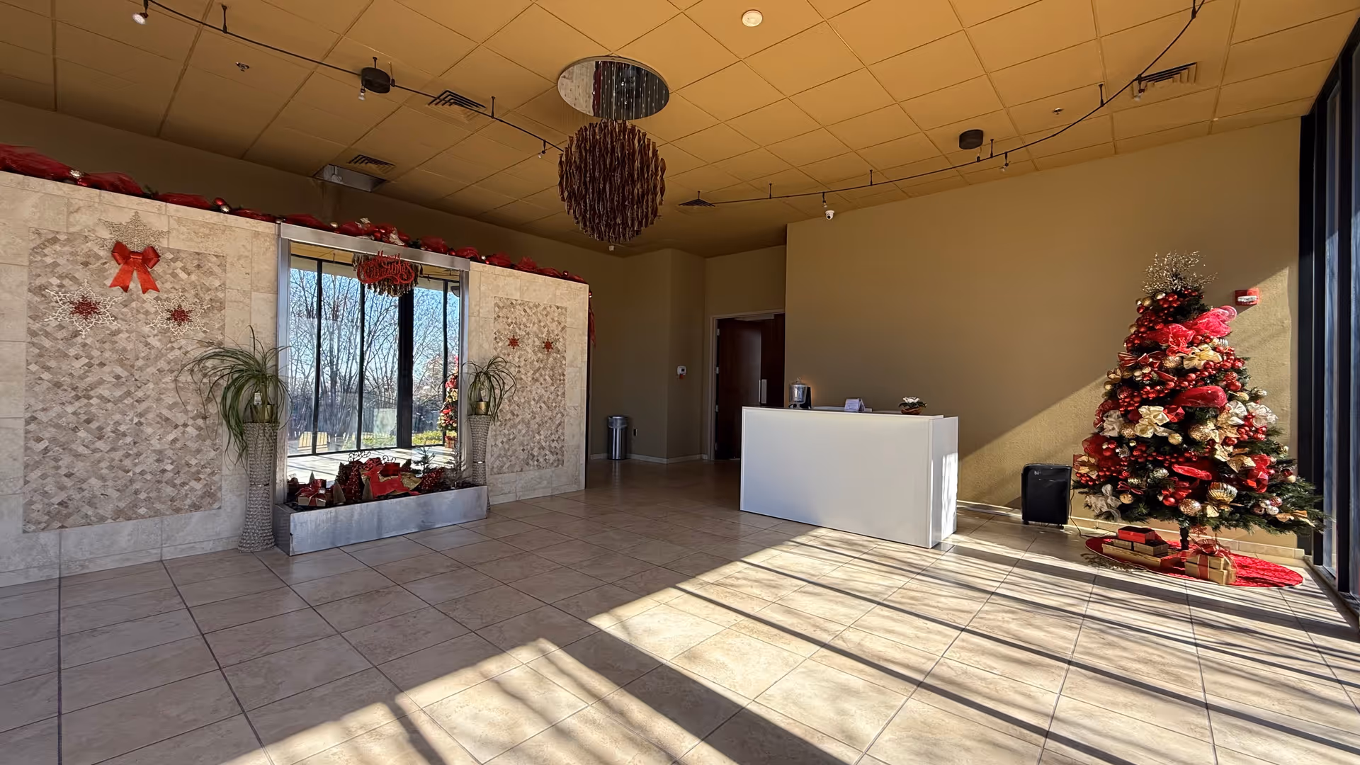 Bright lobby with Christmas tree, reception desk, and large windows