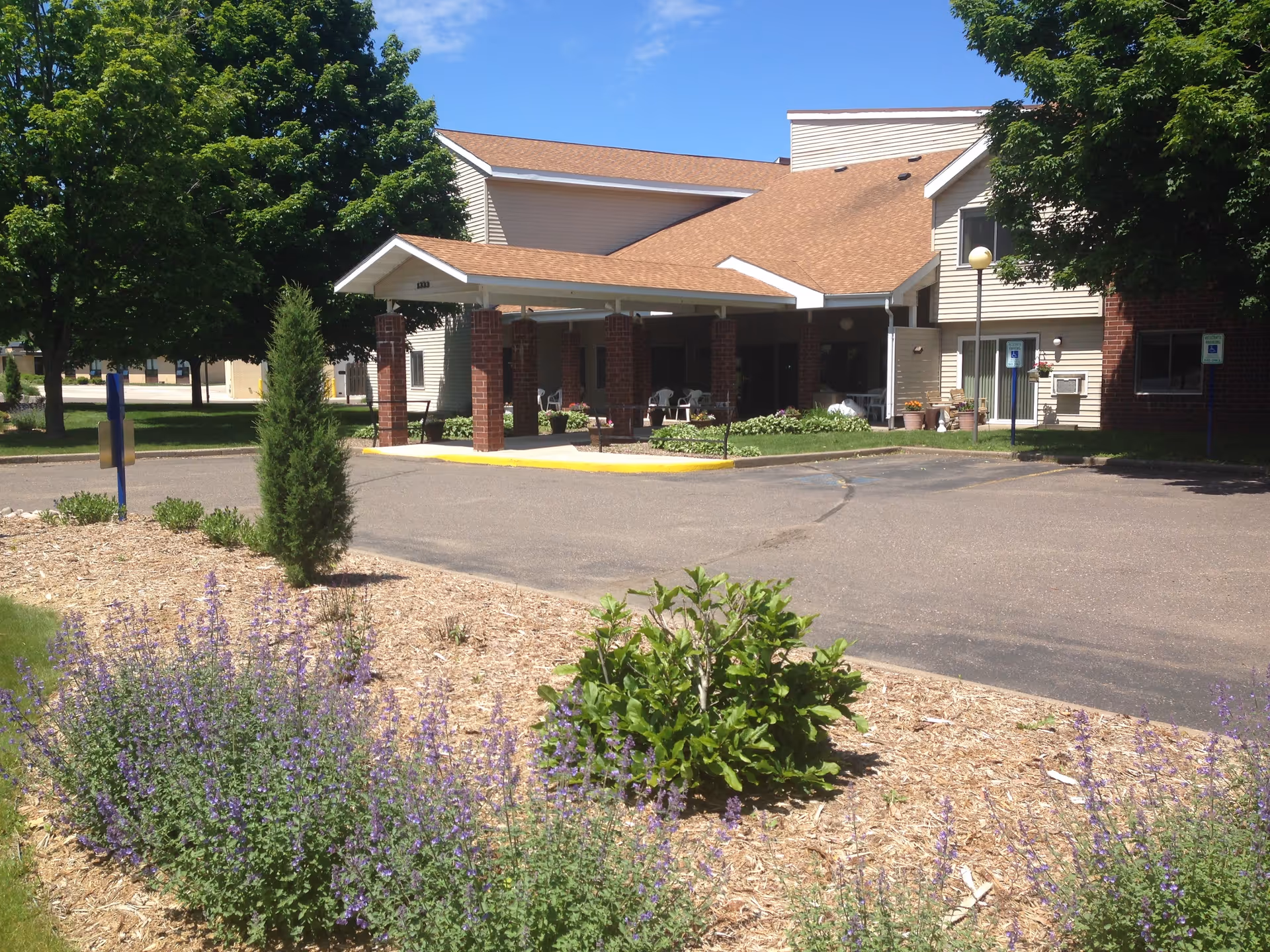Exterior view of Dove Healthcare Barron Assisted Living entrance with a covered drop-off.