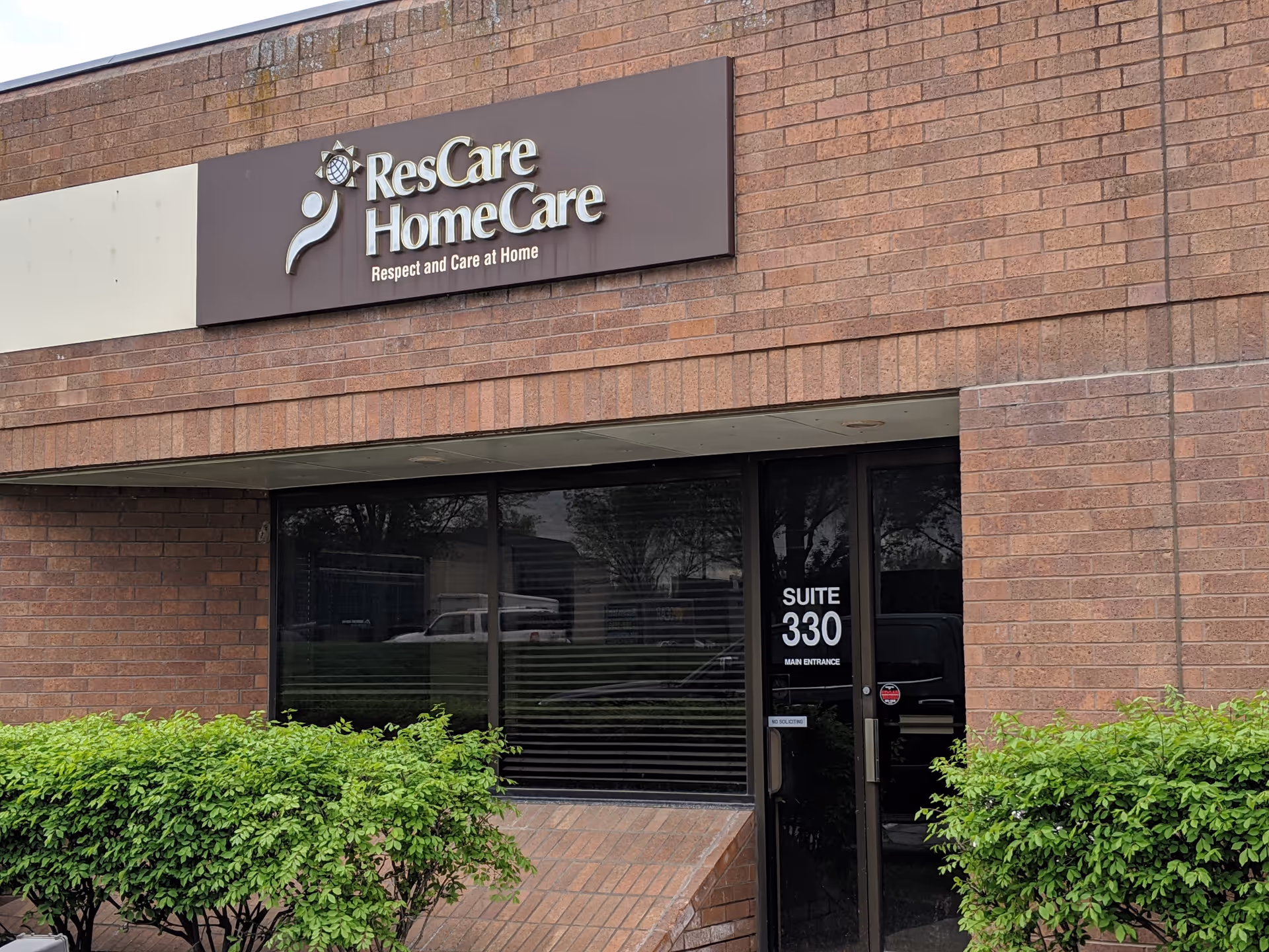 Brick building exterior with ResCare HomeCare sign above glass entrance.